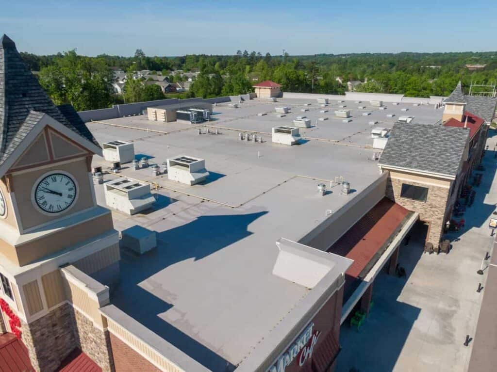 Aerial of a large commercial building with a light-colored roof