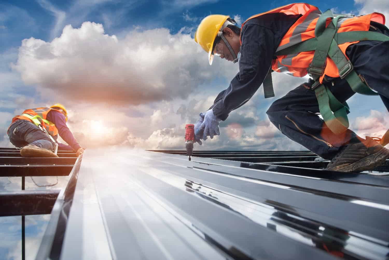 Roofers fastening commercial metal panels